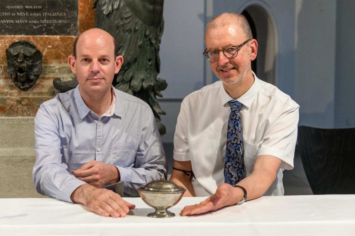 Dr. Jorge Feuchtwanger (Erbe) und Dr. Mathias Weniger (Leitung Provenienzforschung des Bayerischen Nationalmuseums) mit einem der restituierten Silberobjekte.