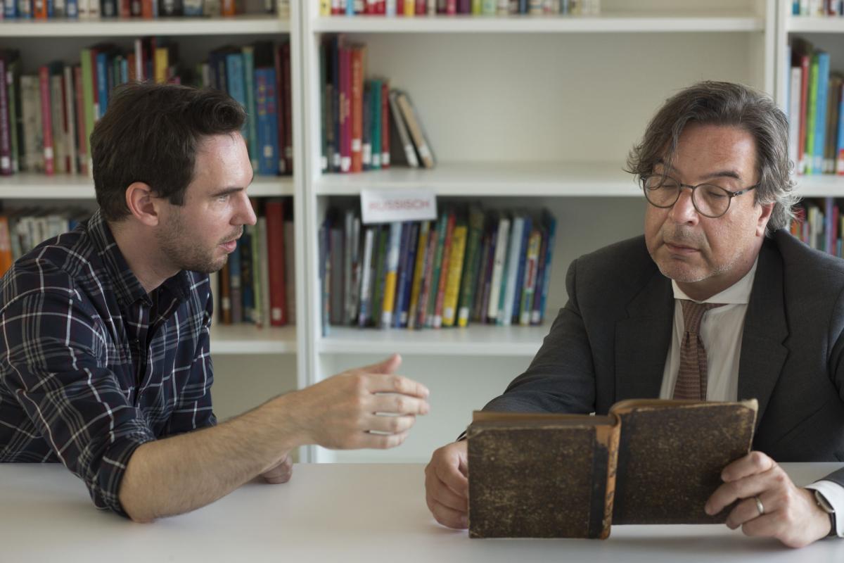 Provenienzforscher Sebastian Braun bei der Übergabe von zwei Büchern an den Kulturdezernenten Marc Grünbaum der Frankfurter jüdischen Gemeinde