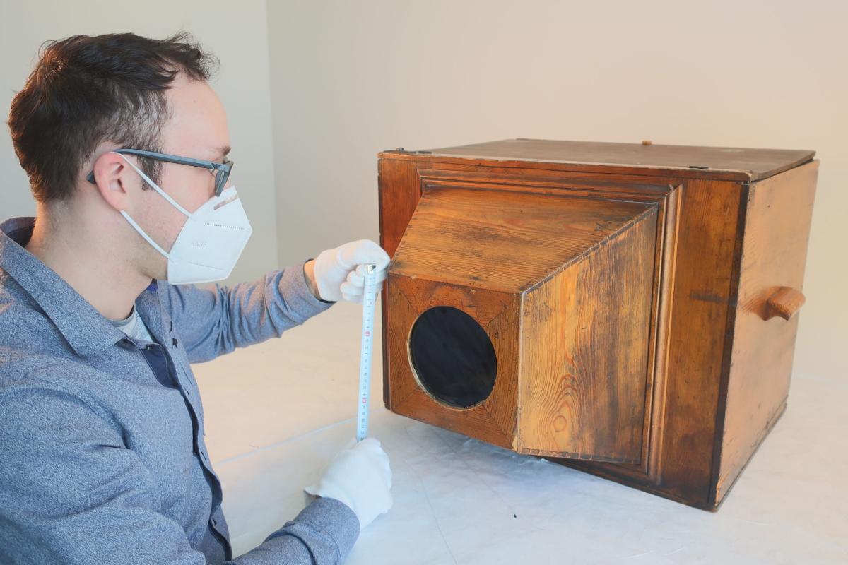 Provenienzforschung zu technischen Kulturgütern am Deutschen Optischen Museum. Dr. Sören Groß führt eine Objektautopsie an einem 1936 erworbenen hölzernen Guckkasten (Inv.Nr. 8736100037154) durch.